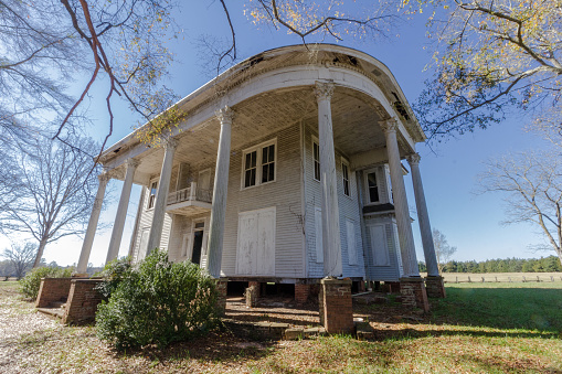 Abandoned plantation home left to rot deep in the south on a clear and sunny day
