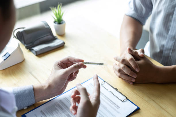 istock Doctor consulting with patient examining for patient, presenting results symptom for using thermometer and recommend treatment method, Healthcare and medical concept 1131628610
