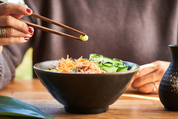 istock Woman eating poke bowl 1131629366