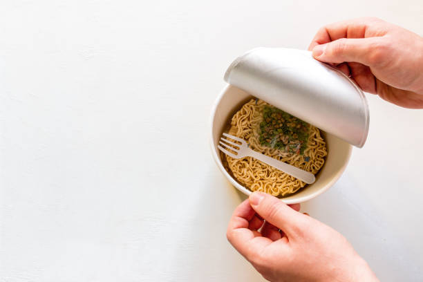 istock man opens the box with instant noodles on a white background with space for text 1131630409
