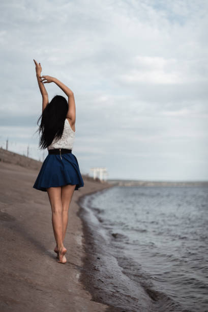 the girl goes along the concrete shore of the hydroelectric power station - quean imagens e fotografias de stock