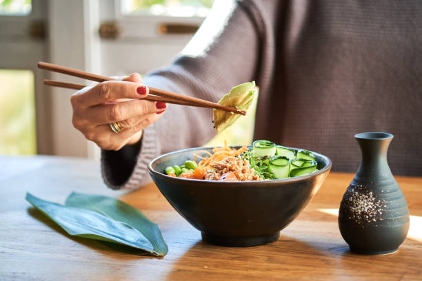 istock Woman eating poke bowl 1131631121