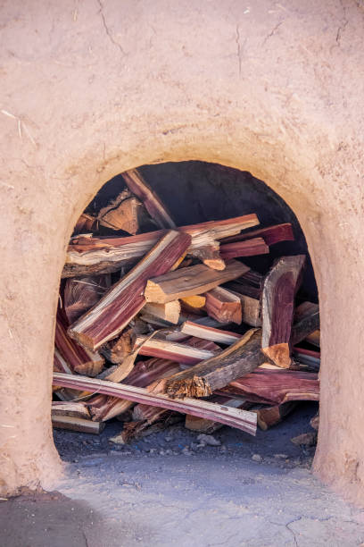 Outdoor Earth Oven in mud pueblo - Horno - closeup filled with split cedar firewood - selective focus Outdoor Earth Oven in mud pueblo - Horno - closeup filled with split cedar firewood - selective focus stove oven adobe outdoors stock pictures, royalty-free photos & images
