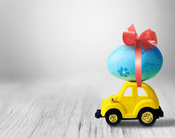 istock Easter egg and toy car on light grey background, happy easter day concept. 1131634494