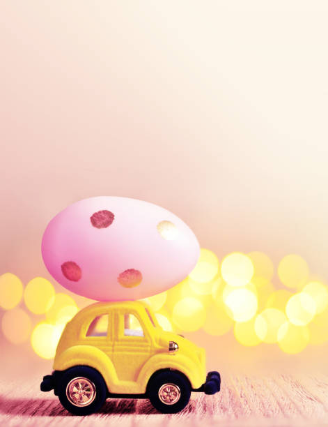 istock Easter egg and toy car on light bokeh background, happy easter day concept 1131634541