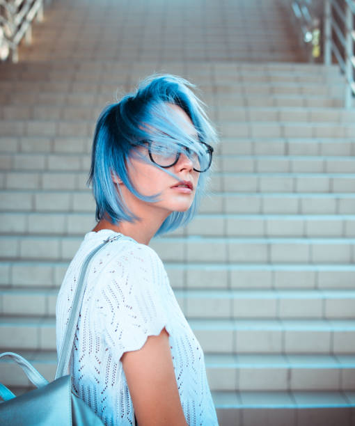 retrato do close-up de vidros desgastando de uma menina do hipster com cabelo azul. beleza atípica. moda de rua. - blue hair - fotografias e filmes do acervo