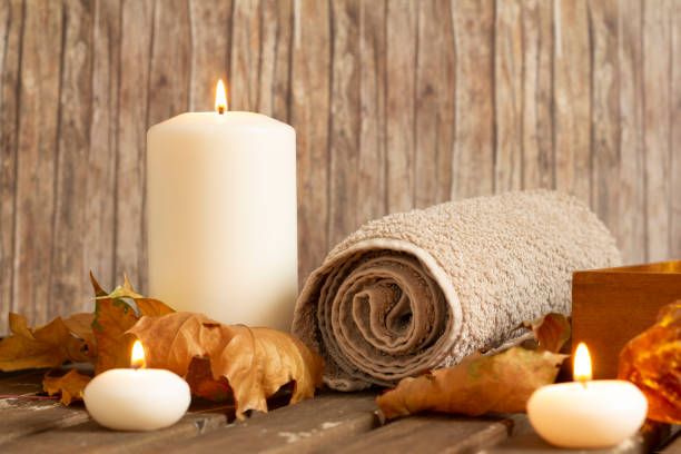 burning candles and towel in spa on wood background stock photo