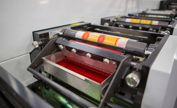 istock Flexographic printing machine with an ink tray, ceramic anilox roll, doctor blade and a print cylinder with polymer relief plate stuck on it. In-line press machine. Rotary or Flexo printing machine. 1131637963