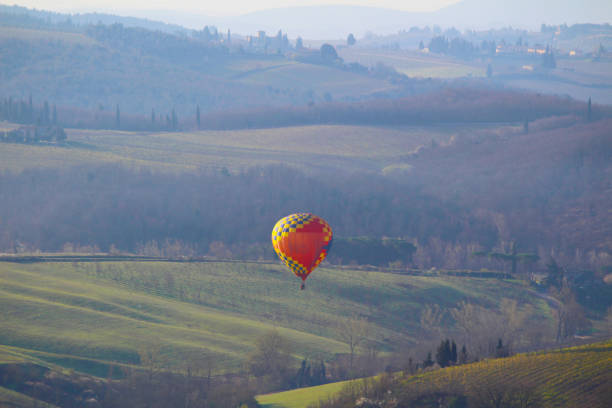 A hot air balloon at sunrise above the Chianti hills south of Florence in Tuscany stock photo