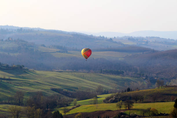A hot air balloon at sunrise above the Chianti hills south of Florence in Tuscany stock photo