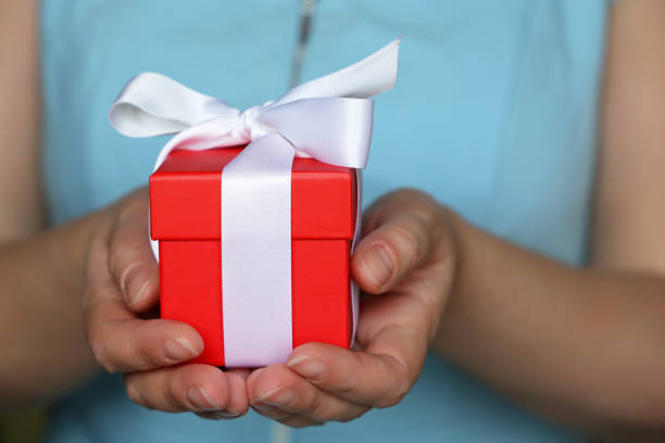 istock Red gift box in female hands close up 1131640885