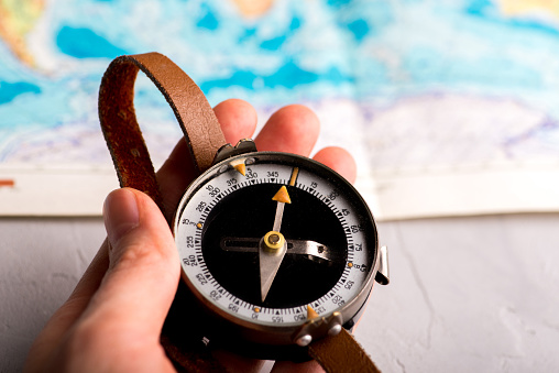 compass in hand against the background of a bright world map