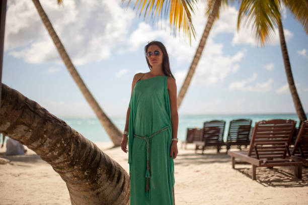 istock oman in under a palm tree enjoying the Caribbean beach 1131648438