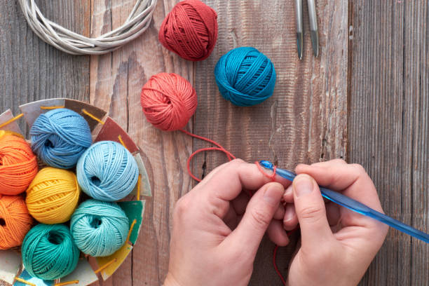 istock Crochet, top view on hands with Crochet hook and yarn balls, top view on rustic wood 1131655408