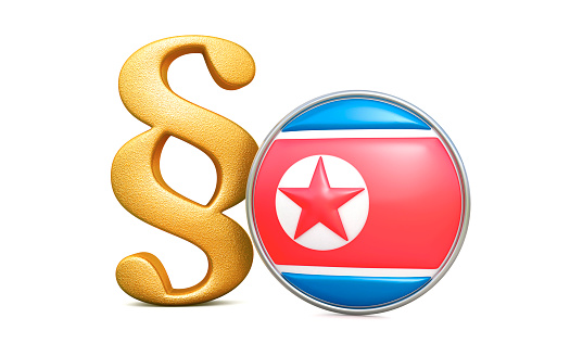 Golden paragraph sign with round flag of the North Korea, 3d render