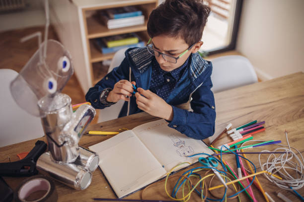 istock Boy making robot toy of recycling material 1131663904