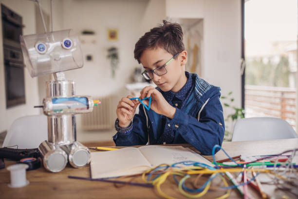 istock Little boy making robot toy of recycling material 1131664150