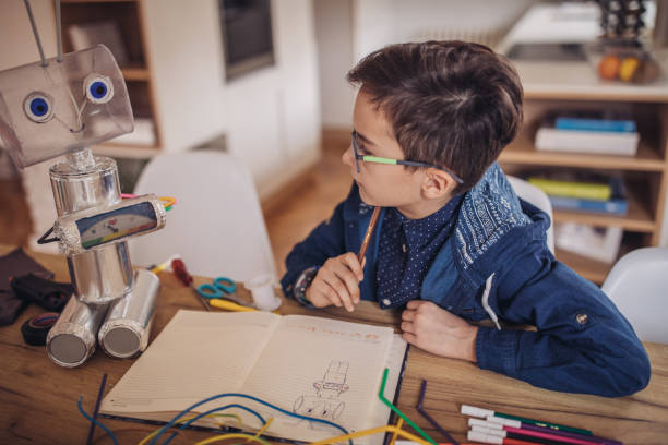 istock Little boy making robot toy of recycling material for school project 1131665186