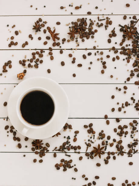 istock Cup of black coffee on a wooden background with spices and coffee grains. Author processing, film effect. 1131665816