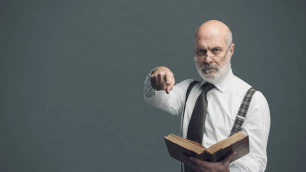 istock Academic professor holding a book and pointing 1131675271