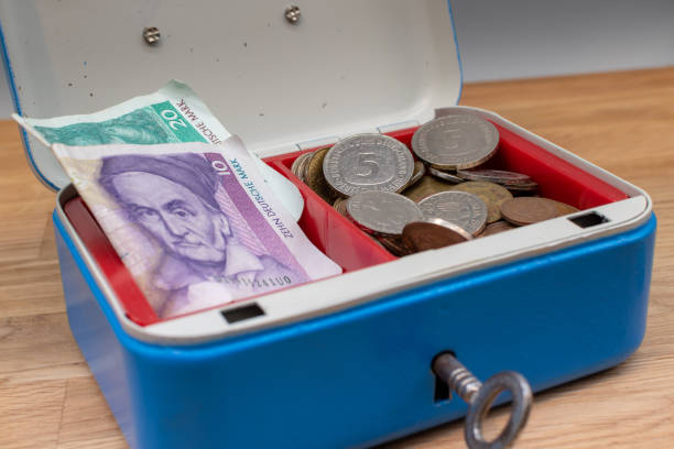 Old German Mark bank notes and coins stored in a blue cash box.
