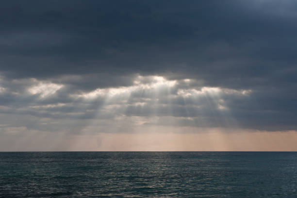 istock Cloudy sky. Dramatic atmosphere created by the sunlight. Sun rays through dark clouds of stormy sky. Rays of light shining through dark clouds 1131678840