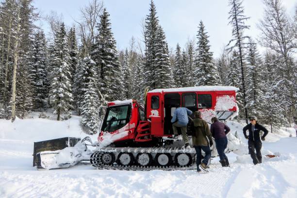 A group of people boarding a red snowcat on the way to the beautiful Island lake Lodge outside of Fernie, British Columbia, Canada stock photo