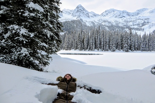 A young woman having fun around Island Lake in Fernie, British Columbia, Canada.  The majestic winter background is an absolutely beautiful place to go hiking or snowshoeing with fresh fallen snow.