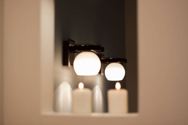 istock Wall lamps with white shade and blurred candles. 1131684871