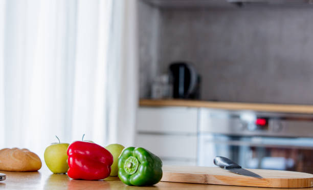 istock Green and red peppers with apple an knife 1131686768