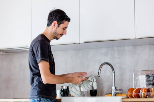 istock Young man in black shirt cooking at kitchen in home. 1131687528