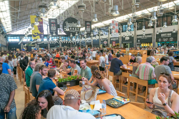 People having lunch at the famous Time Out market Lots of people come to have lunch at Time Out market in Lisbon. food court photos stock pictures, royalty-free photos & images