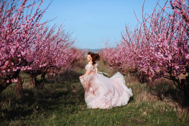 istock Beautiful young girl under the flowering pink tree 1131697879