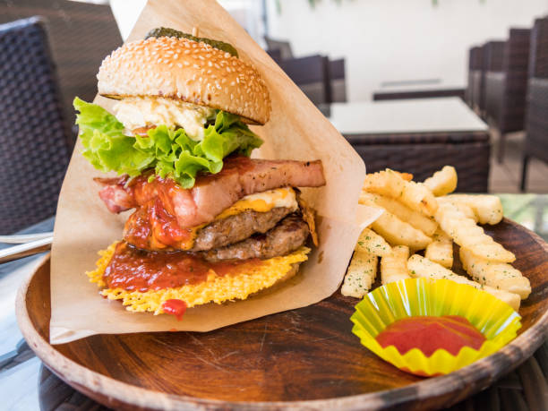 A hamburger with a volume with bacon and meat in between.