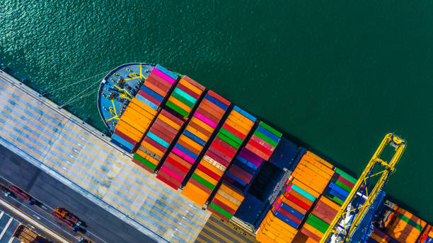 nave de carga del cargamento del envase con la descarga de trabajo del puente de la grúa en el terminal del envase, nave superior aérea del envase de la visión en puerto de alta mar - ship freight transportation cargo container sea fotografías e imágenes de stock