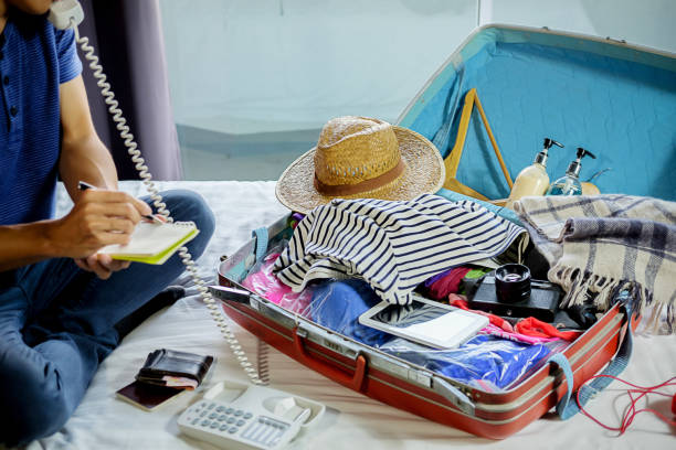 istock People packed suitcase with travel accessories on bed. Vacation concept 1131715139