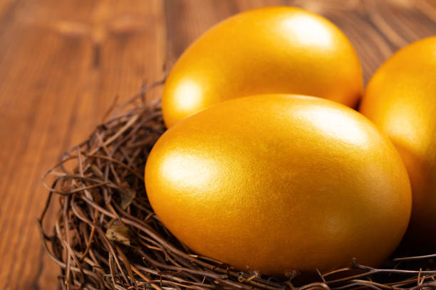 istock gold eggs on a nest on wooden background close up 1131717992