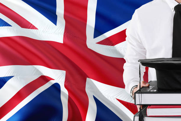 istock Successful British student education concept. Holding books and graduation cap over United Kingdom flag background. 1131724556