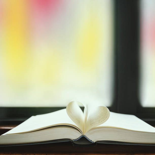 istock Heart shape paper book on table in library. 1131725193