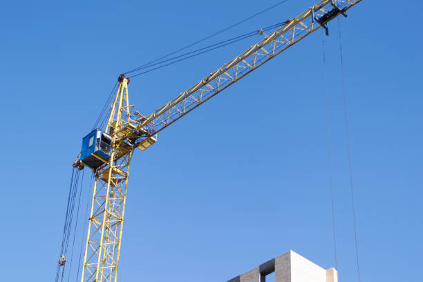 istock Crane and building under construction against blue sky 1131728160