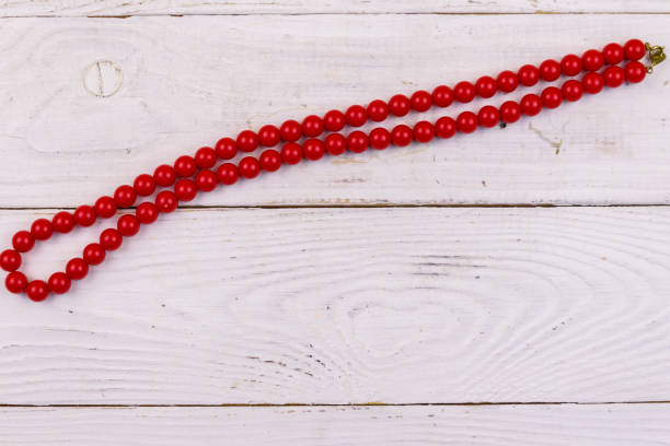 istock Red beads necklace on white wooden background. Top view 1131730470