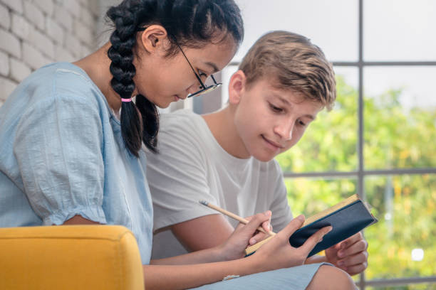 istock teenager reading book together 1131732675