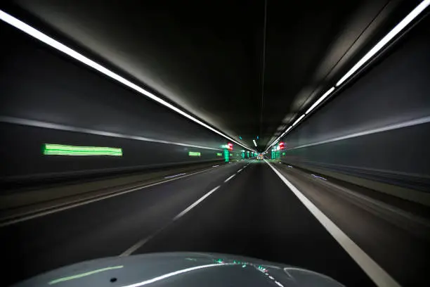 A car in a tunnel in the night with lights