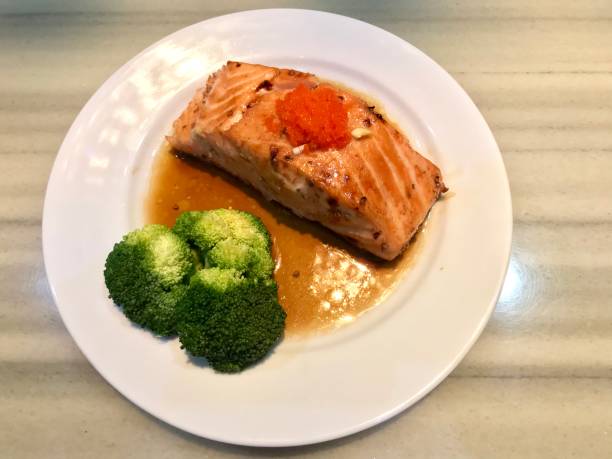 istock Salmon steak with broccoli in white dish 1131745237