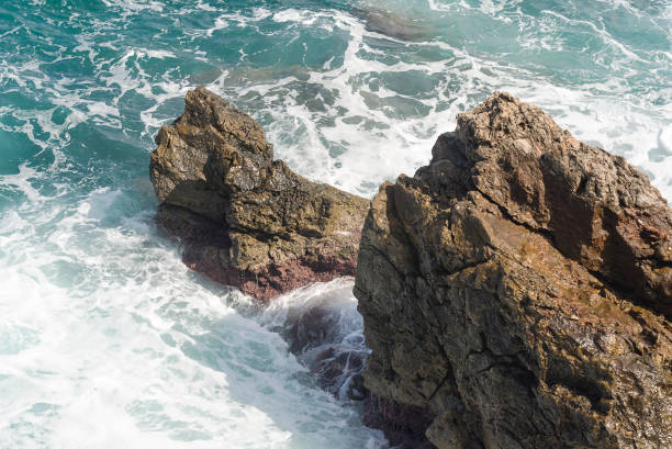 istock The waves breaking on a stony beach, forming a spray. Wave and splashes on beach. Waves crashing onto rocks. 1131745473