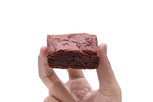 istock hand holding cake chocolate brownies isolated on white background - clipping paths 1131749468