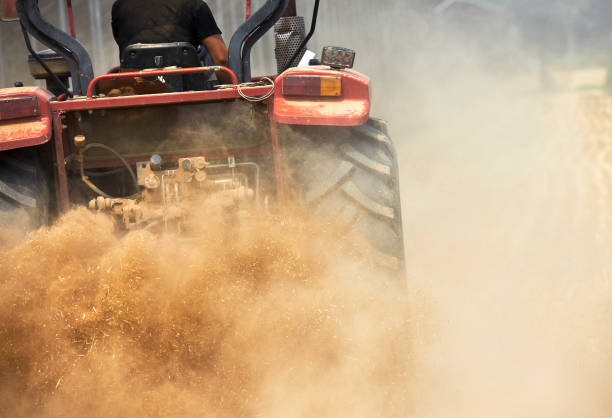 Agricultural tractor lifting dust close-up