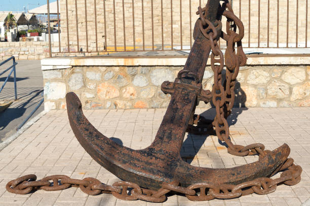 istock Old anchor lies on stones. Sunny day 1131753155