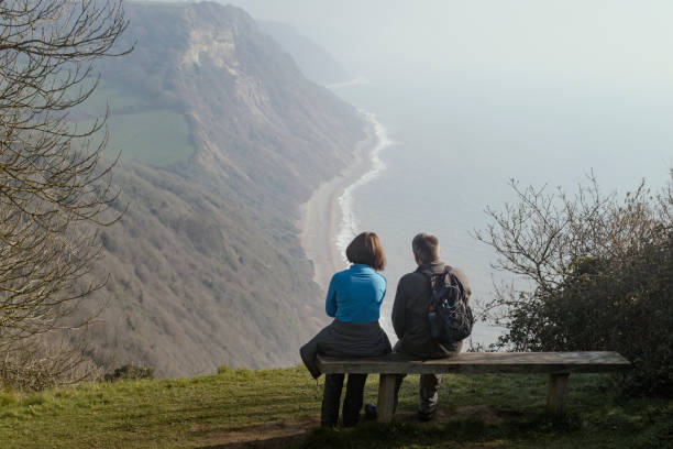 Hikers resting looking at English countryside, coast line