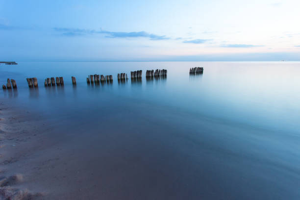 istock smooth sea surface and breakwaters in blue twilight on long exposure 1131758446